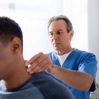 El médico realiza un examen de diagnóstico de un paciente con dolor de cuello. 
