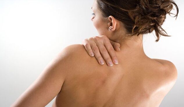 La mujer está preocupada por el dolor debajo del omóplato izquierdo en la espalda desde la espalda. 